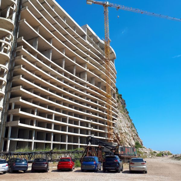 House construction with crane and parked cars in Petrovac, Montenegro